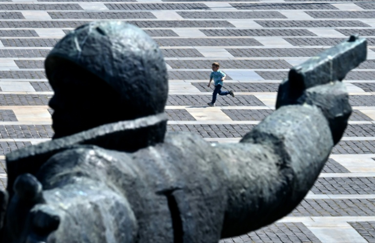 Un garçon court devant le monument "Passage du Dniepr" au Musée national d'histoire de l'Ukraine pendant la Seconde Guerre mondiale, le 9 mai 2026 à Kiev ( AFP / Sergei SUPINSKY )