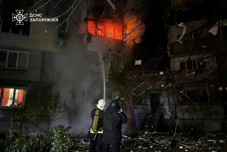 Photo publiée par le service d'urgence ukrainien, le 22 octobre 2025, de sauveteurs ukrainiens luttant contre un incendie dans un immeuble résidentiel après une frappe aérienne russe à Zaporijjia ( Service d'urgence ukrainien / Handout )