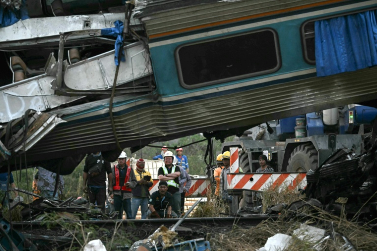 Des secouristes sur le site du déraillement d'un train provoqué par l'effondrement d'une grue de chantier dans la province de Nakhon Ratchasima, en Thaïlande, le 14 janvier 2026 ( AFP / Lillian SUWANRUMPHA )