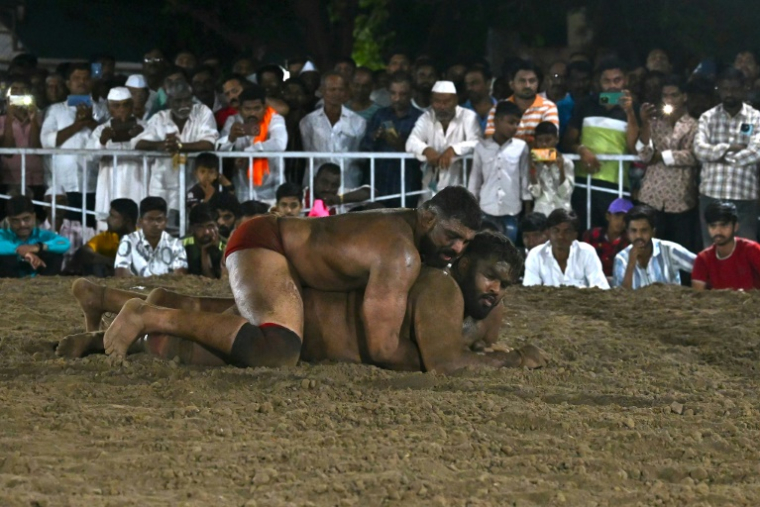 Le lutteur Mauli Jamdade bloque son adversaire Bala Rafique Shaikh lors du match final d'une compétition de lutte Kusthi à Shirwal, dans l'État du Maharashtra, le 1er mai 2025 en Inde ( AFP / Indranil MUKHERJEE )