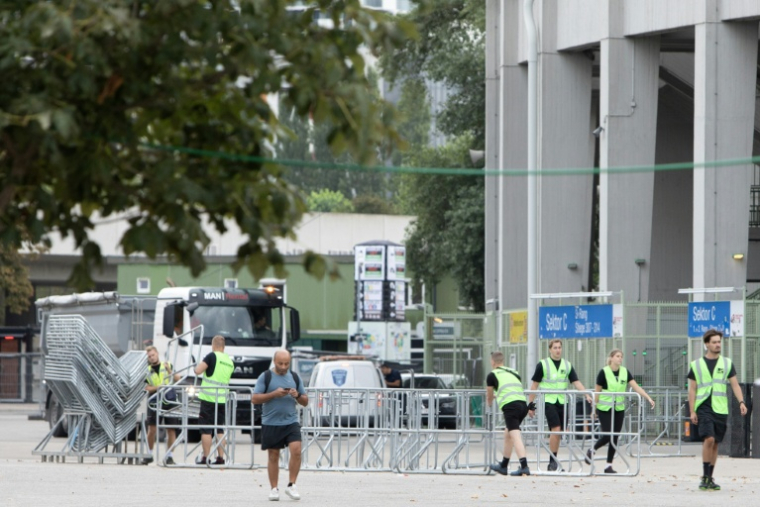Des agents de sécurité retirent les barrières devant le stade Ernst Happel à Vienne, où les trois concerts de la superstar américaine Taylor Swift ont été annulés après l'arrestation d'un sympathisant de l'État islamique soupçonné de préparer un attentat, le 8 août 2024 en Autriche ( AFP / Alex HALADA )