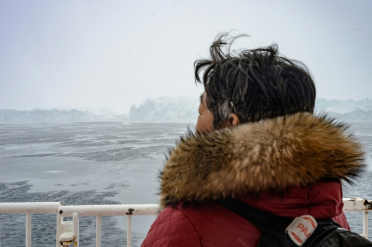 Une femme observe les icebergs de l'Icefjord depuis le pont du ferry Sarfaq Ittuk, près d'Ilulissat, au Groenland, le 15 mars 2026 ( AFP / Florent VERGNES )