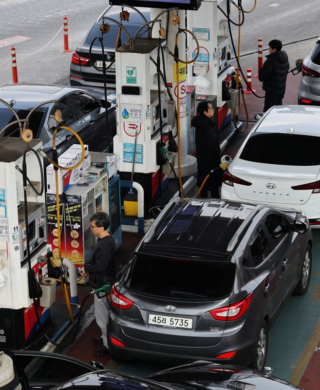 Des personnes font le plein de leur voiture dans une station-service de Séoul