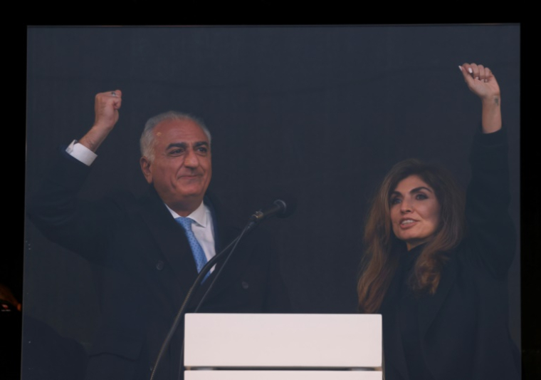 Le fils du chah déchu, Reza Pahlavi, lève le poing sur scène aux côtés de son épouse Yasmine Pahlavi lors d'une manifestation de l'opposition iranienne à Munich, en Allemagne, le 14 février 2026 ( AFP / Michaela STACHE )