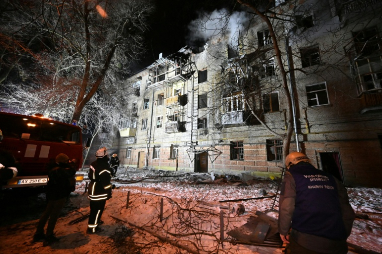 Les services de secours ukrainiens travaillent autour d'un immeuble endommagé par des frappes russes à Kharkiv le 24 janvier 2026 ( AFP / SERGEY BOBOK )