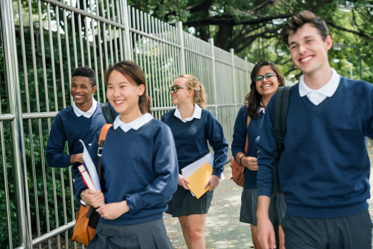 (Crédits photo : Adobe Stock - Collégiens en uniforme sortant de leur établissement scolaire)
