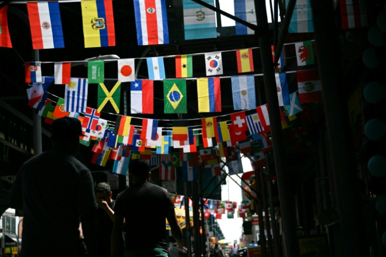 Les drapeaux des pays participant au Mondial-2026 dans une rue de l'arrondissement du Queens, à New York, le 11 juin 2026 ( AFP / ANGELA WEISS )