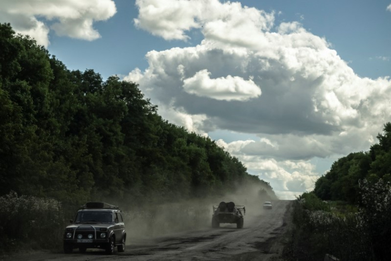 Des militaires ukrainiens montent à bord d'un véhicule blindé de transport de troupes près de la frontière russe, dans la région de Sumy
