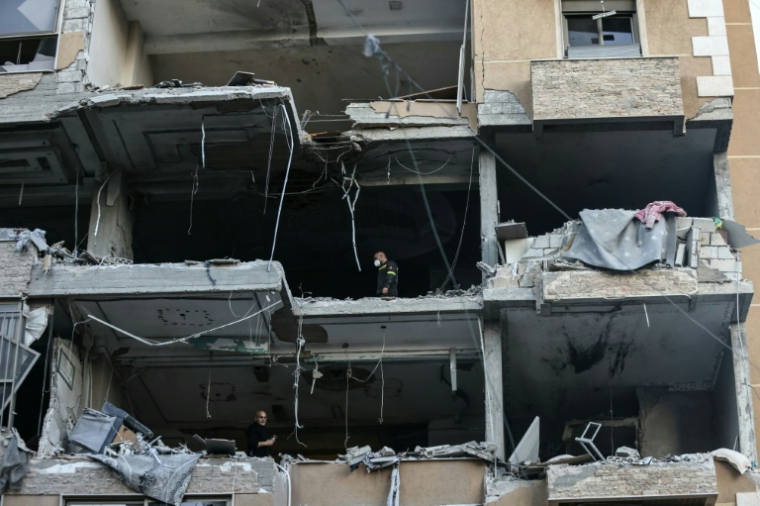 Des secouristes dans un immeuble détruit par une frappe aérienne israélienne dans le quartier de Aïcha Bakkar à Beyrouth, le 11 mars 2026 au Liban ( AFP / IBRAHIM AMRO )