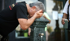 Un homme se rafraichit à une fontaine publique à Paris le 18 juin 2026 ( AFP / SIMON WOHLFAHRT )