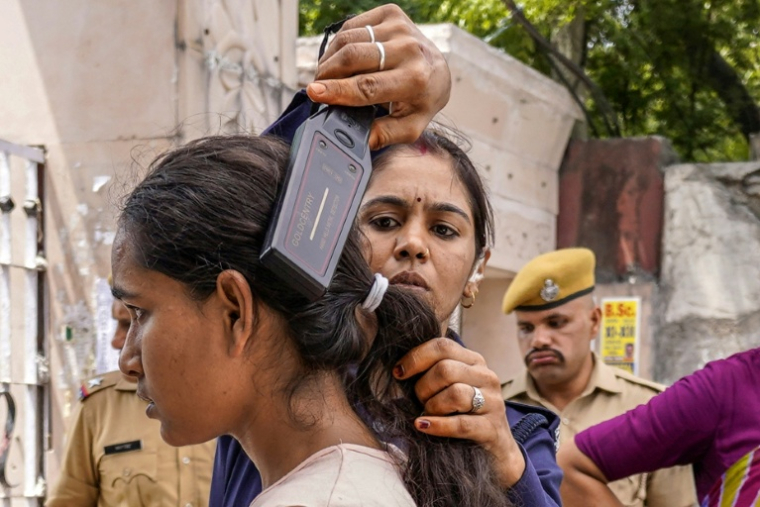 Une étudiante en médecine est contrôlée par un policier avant de se présenter à l'examen de rattrapage NEET-UG à Kota, dans l'État du Rajasthan, le 21 juin 2026 en Inde ( AFP / HIMANSHU SHARMA  )