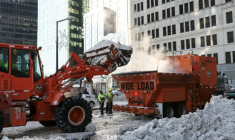 Une pelleteuse déverse la neige dans une fondeuse à neige dans le quartier de Manhattan, à New York, le 29 janvier 2026 ( AFP / ANGELA WEISS )