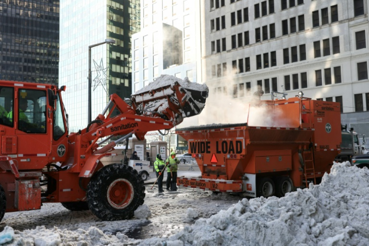 Une pelleteuse déverse la neige dans une fondeuse à neige dans le quartier de Manhattan, à New York, le 29 janvier 2026 ( AFP / ANGELA WEISS )