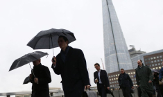 Des employés s'abritant de la pluie à Londres