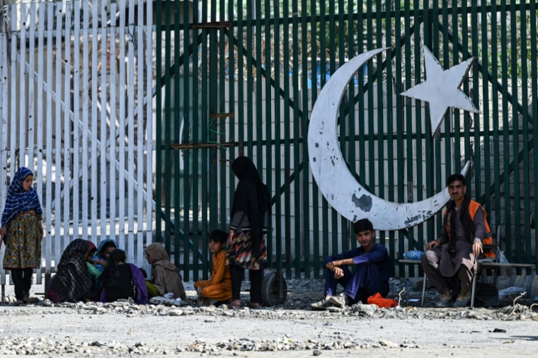 Le 20 avril 2025, des travailleurs afghans attendent au poste frontière de Torkham, alors que le Pakistan mène une campagne d'expulsion visant plus de 800.000 Afghans d’ici fin avril ( AFP / Wakil KOHSAR )
