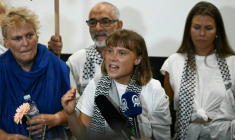 La militante suédoise pour le climat Greta Thunberg (au centre) prononce un discours à son arrivée à l'aéroport d'Athènes le 6 octobre 2025, aux côtés de militants qui naviguaient à bord de la flottille pour Gaza avant d'être arrêtés et expulsés par les forces israéliennes. ( AFP / Aris MESSINIS )