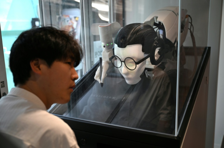 Un robot IA livre ses prédictions à un visiteur, le 15 avril 2026 à Séoul ( AFP / Jung Yeon-je )