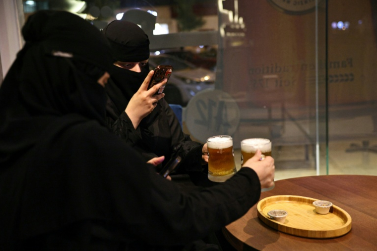 Deux femmes prennent en photo leur bière sans alcool à Ryad, Arabie saoudite, le 24 octobre 2025 ( AFP / Fayez Nureldine )