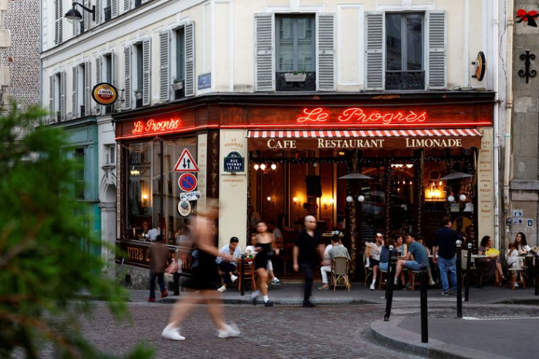 Des gens passent devant un restaurant à Paris