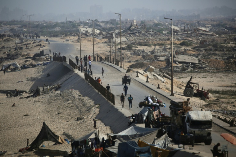 Des Palestiniens marchent sur un sentier côtier au nord-ouest du camp de réfugiés de Nousseirat, dans la bande de Gaza assiégée, le 4 octobre 2025 ( AFP / Eyad BABA )