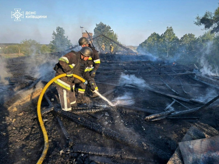 Image fournie par les services d'urgence ukrainiens de pompiers ukrainiens qui éteignent un incendie après une frappe de drone russe à Kiev le 12 mai 2026 ( State Emergency Service of Ukraine / Handout )