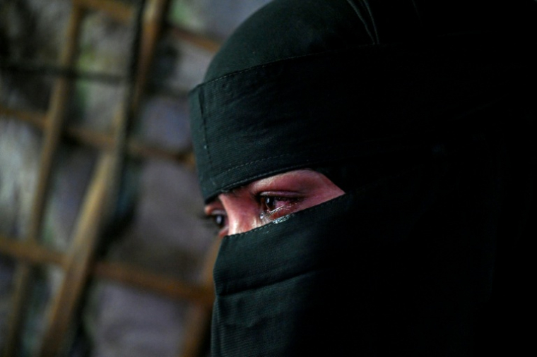 La réfugiée rohingya Rahela Begum, qui a passé deux jours et une nuit à la dérive en mer d'Andaman, accrochée à une planche de bois, avant d'être secourue, pleure lors d'un entretien avec l'AFP au camp de réfugiés de Kutupalong, à Cox's Bazar, le 20 juin 2026 au Bangladesh ( AFP / Munir UZ ZAMAN )