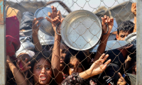 Des Palestiniens, principalement des enfants, se bousculent pour recevoir un repas chaud dans une cuisine opérée par une organisation de charité locale à al-Mawassi dans le sud de la bande de Gaza, le 22 juillet 2025 ( AFP / - )