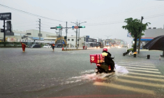 Photo fournie par le Bureau des pompiers de la ville de Tainan, montrant un livreur à scooter qui traverse une intersection inondée à Tainan sur l'île de Taïwan, le 2 août 2025. ( Tainan City Government Fire Bureau / Handout )