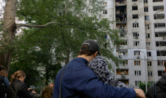 Des habitants observent un immeuble résidentiel endommagé après une frappe de drone russe à Kiev, le 25 septembre 2026 ( AFP / Tetiana DZHAFAROVA )