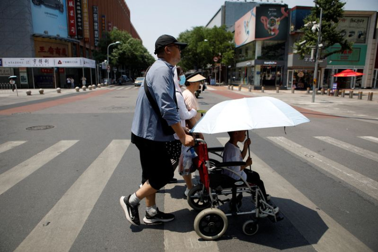 Des piétons lors d'une journée de canicule, à Pékin