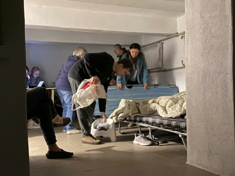 Des habitants s'installent pour dormir dans le sous-sol de leur immeuble résidentiel lors d'une attaque nocturne de drones et de missiles sur Kiev le 23 juin 2025 ( AFP / Ania TSOUKANOVA )