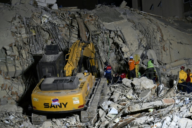Des équipes de secours utilisent des engins de chantier sur le site d'un immeuble effondré à Caracas, le 25 juin 2026, à la suite de séismes ( AFP / Juan BARRETO )