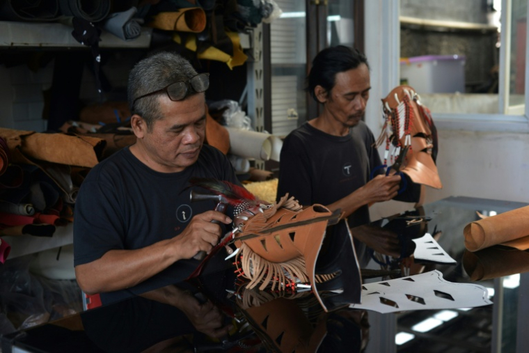 Des ouvriers au travail pour fabriquer des bottes western dans l'atelier Tegep Boots, à Bandung (ouest de Java), le 15 juillet 2025 ( AFP / Timur MATAHARI )