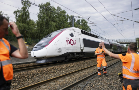 Un TGV Inoui passe près de techniciens de la SNCF qui travaillent à reconnecter les câbles ferroviaires à la gare de Mont-de-Terre à Lille, le 25 juin 2025 dans le Nord ( AFP / Sameer Al-DOUMY )