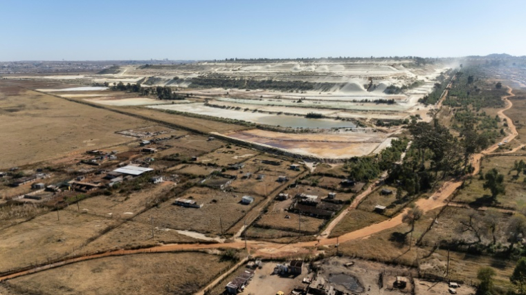 Vue aérienne de parcelles agricoles et de talus miniers en arrière-plan, dans le quartier de Snake Park, à Soweto, le 30 mai 2025 en Afrique du Sud ( AFP / EMMANUEL CROSET )