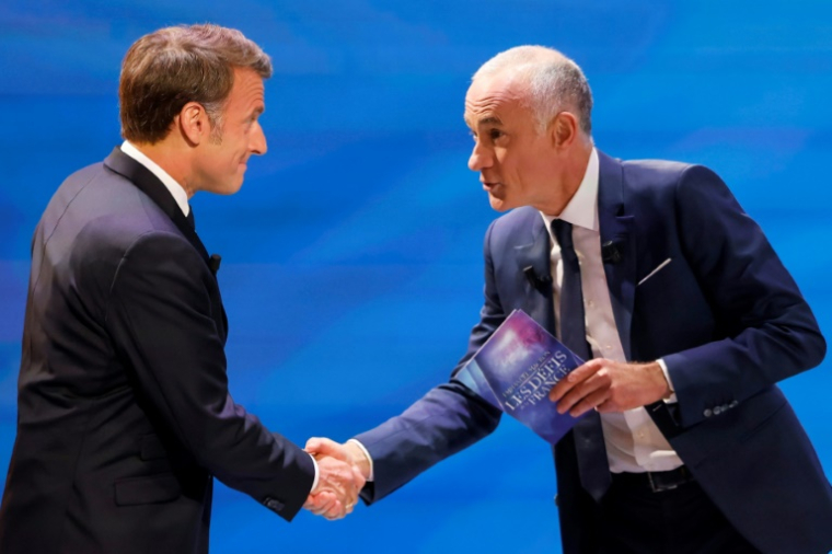 Emmanuel Macron accueilli mardi soir sur TF1 par le journaliste Gilles Bouleau. ( POOL / Ludovic MARIN )