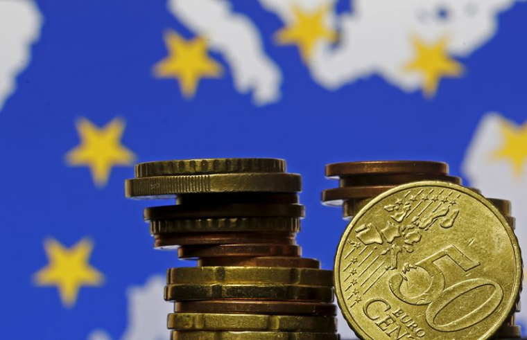 Pièces en euros devant le drapeau et la carte de l'Union européenne
