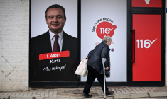 Un personne passe devant une affiche du Premier ministre sortant Albin Kurti, à Pristina, le 23 décembre 2025 ( AFP / Armend NIMANI )