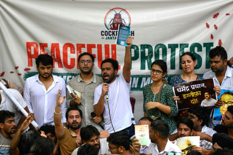Le fondateur du "parti du peuple des cafards" Abhijeet Dipke (au centre), lors de la manifestation réclamant la démission du ministre de l'Education à New Delhi, le 6 juin 2026 ( AFP / Manan VATSYAYANA )