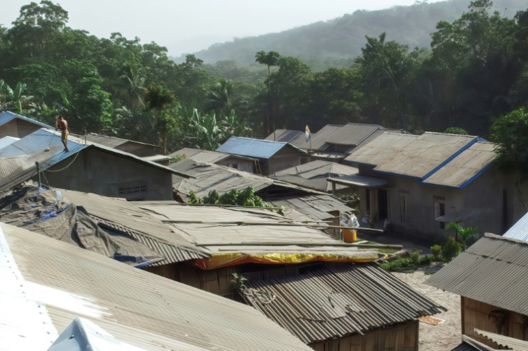Des villageois nettoient les toits de leurs maisons des cendres volcaniques au lendemain de l'éruption du mont Lewotobi Laki-Laki à Sikka, dans l'est de Nusa Tenggara, le 18 juin 2025 en Indonésie ( AFP / ARNOLD WELIANTO )