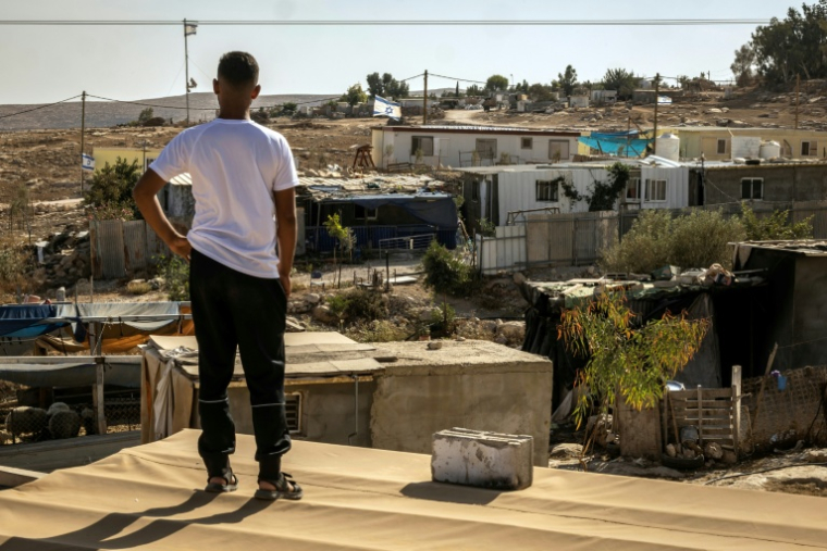 Un Palestinien regarde des installations israéliennes depuis le toit d'une maison dans son village d'Oum al-Khair, le 2 novembre 2025, en Cisjordanie occupée ( AFP / FADEL SENNA )