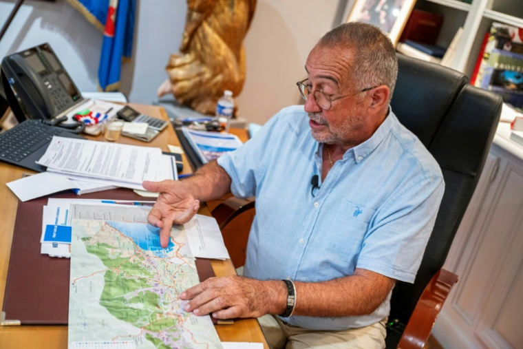 Le maire de Grimaud, Alain Benedetto, montre le port de Grimaud sur une carte lors d'un entretien avec l'AFP dans son bureau de la mairie, le 9 septembre 2026 dans le Var ( AFP / Miguel MEDINA )