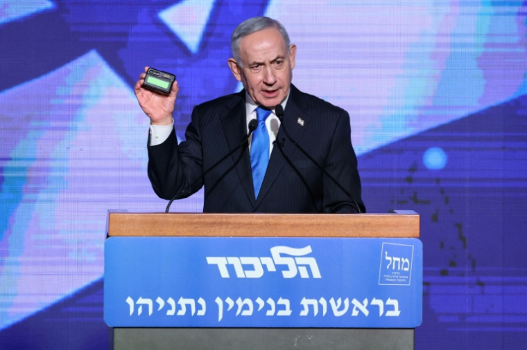 Le Premier ministre israélien Benjamin Netanyahu montre un pager présenté comme appartenant au Hezbollah lors d'une cérémonie de vœux pour le Nouvel An juif, en présence de membres du Likoud, le 17 septembre 2026 à Tel-Aviv ( AFP / Jack GUEZ )