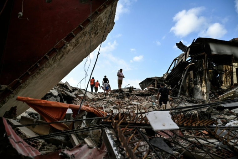Des équipes de secours recherchent des victimes dans un immeuble effondré après deux séismes, à Caraballeda, dans l'Etat de La Guaira, le 27 juin 2026 au Venezuela ( AFP / Maryorin Mendez )