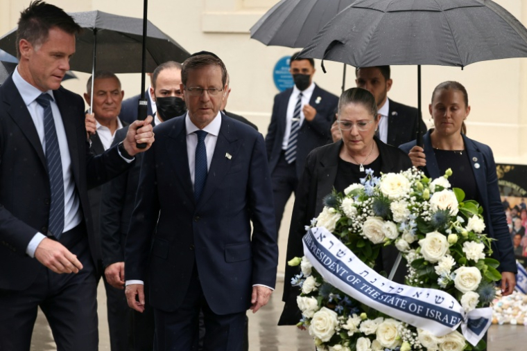 Le président israélien Isaac Herzog (c) et son épouse Michal (2e d) accompagnés par le Premier ministre de Nouvelle-Galles du Sud, Chris Minns (g), déposent une gerbe en hommage aux victimes de l'attaque du 14 décembre 2025 au Bondi Pavilion, à Sydney, le 9 février 2026 en Australie ( AFP / David GRAY )