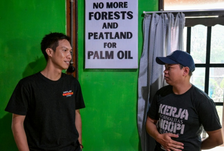Bayu Herinata (g), du groupe environnemental WALHI Kalimantan central, et un membre de son équipe à Palangkaraya, dans le Kalimantan central, le 10 février 2026 en Indonésie ( AFP / BAY ISMOYO )