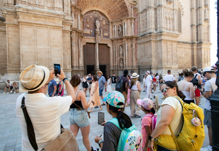 Des touristes visitent la cathédrale de Palma de Majorque, le 1er août 2025 aux Baléares, en Espagne ( AFP / JAIME REINA )