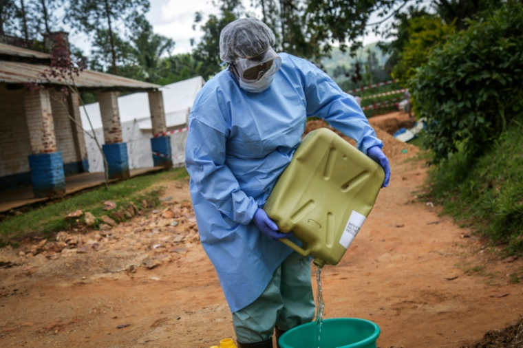 Une soignante portant un équipement de protection prépare du matériel désinfectant en vue de désinfecter la zone d'isolement des patients atteints d'Ebola, le 23 mai 2026 à l'hôpital général de Mongbwalu (République démocratique du Congo) ( AFP / Seros MUYISA )