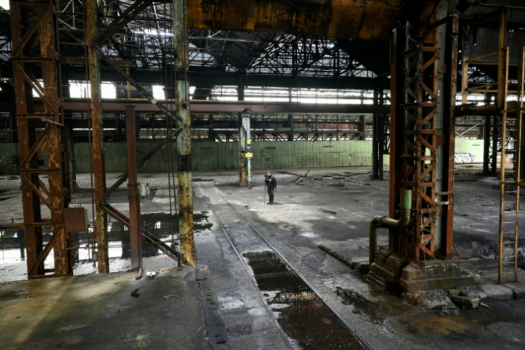 Un explorateur urbain (urbex) prend des photos dans une aciérie à l'abanon à Charleroi, dans le sud de la Belgique, le 9 février 2026 ( AFP / Nicolas TUCAT )