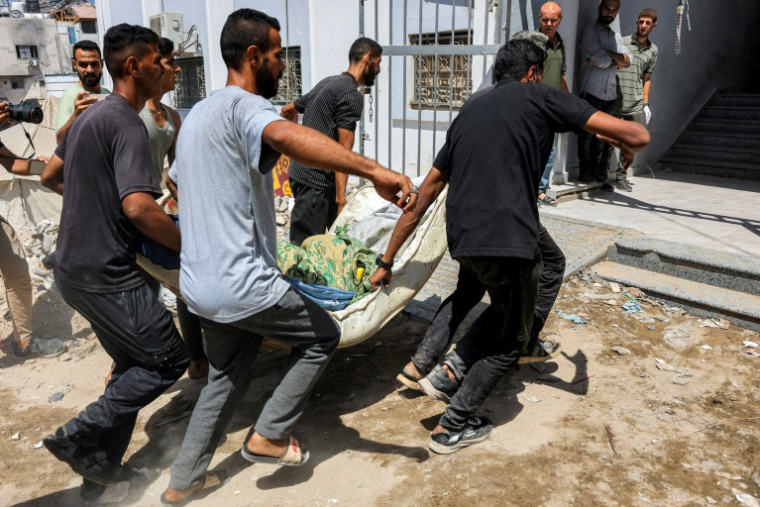 Des hommes portent le corps d'un Palestinien tué dans un bombardement israélien sur un camp de déplacés, à l'hôpital al-Chifa de la ville de Gaza, le 4 septembre 2025 ( AFP / Omar AL-QATTAA )
